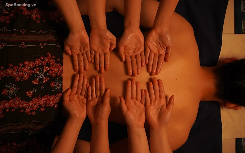Holistic eight hands massage reducing stress and improving circulation.