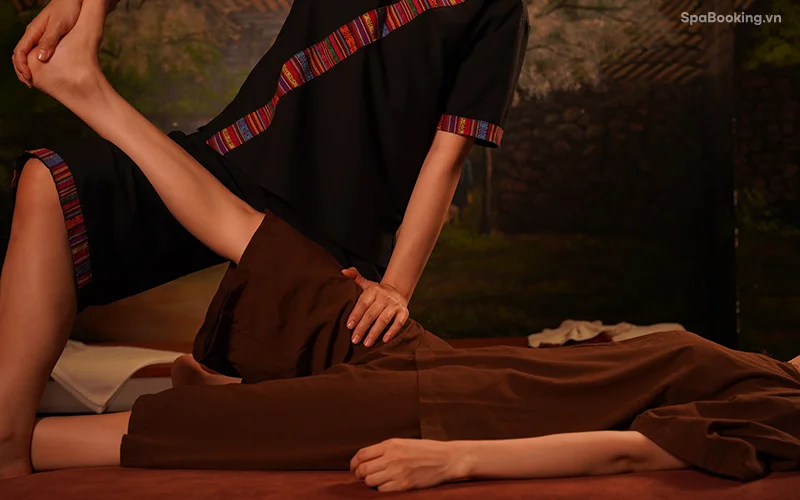 Buổi massage Thái tại spa với bối cảnh tự nhiên và trang phục truyền thống, tạo sự thư giãn tối đa.